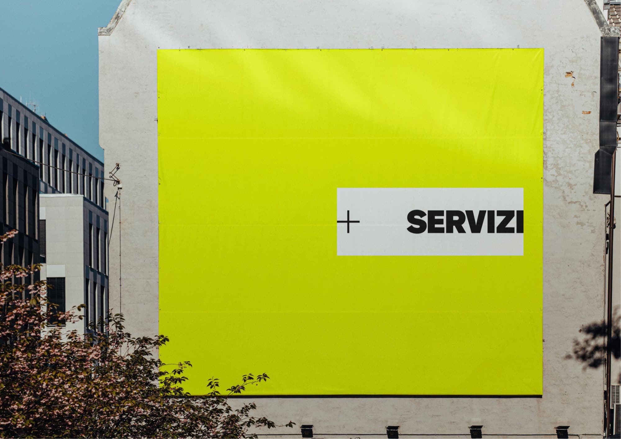 Maxi affissione gialla con il logo Più Servizi sulla facciata di un edificio